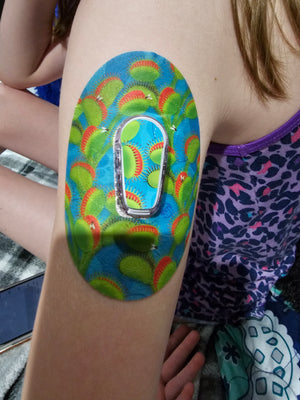 Young girl with Venus Fly Trap Dexcom G6 Tape and Transmitter Sticker on arm
