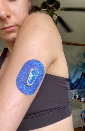 Woman with Watercolor Waves Dexcom G6 Mini Tape and Transmitter Sticker on arm