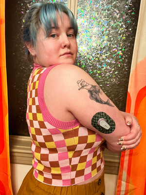 Woman with Green & Black Checkerboard Dexcom G6 Mini Tape on arm