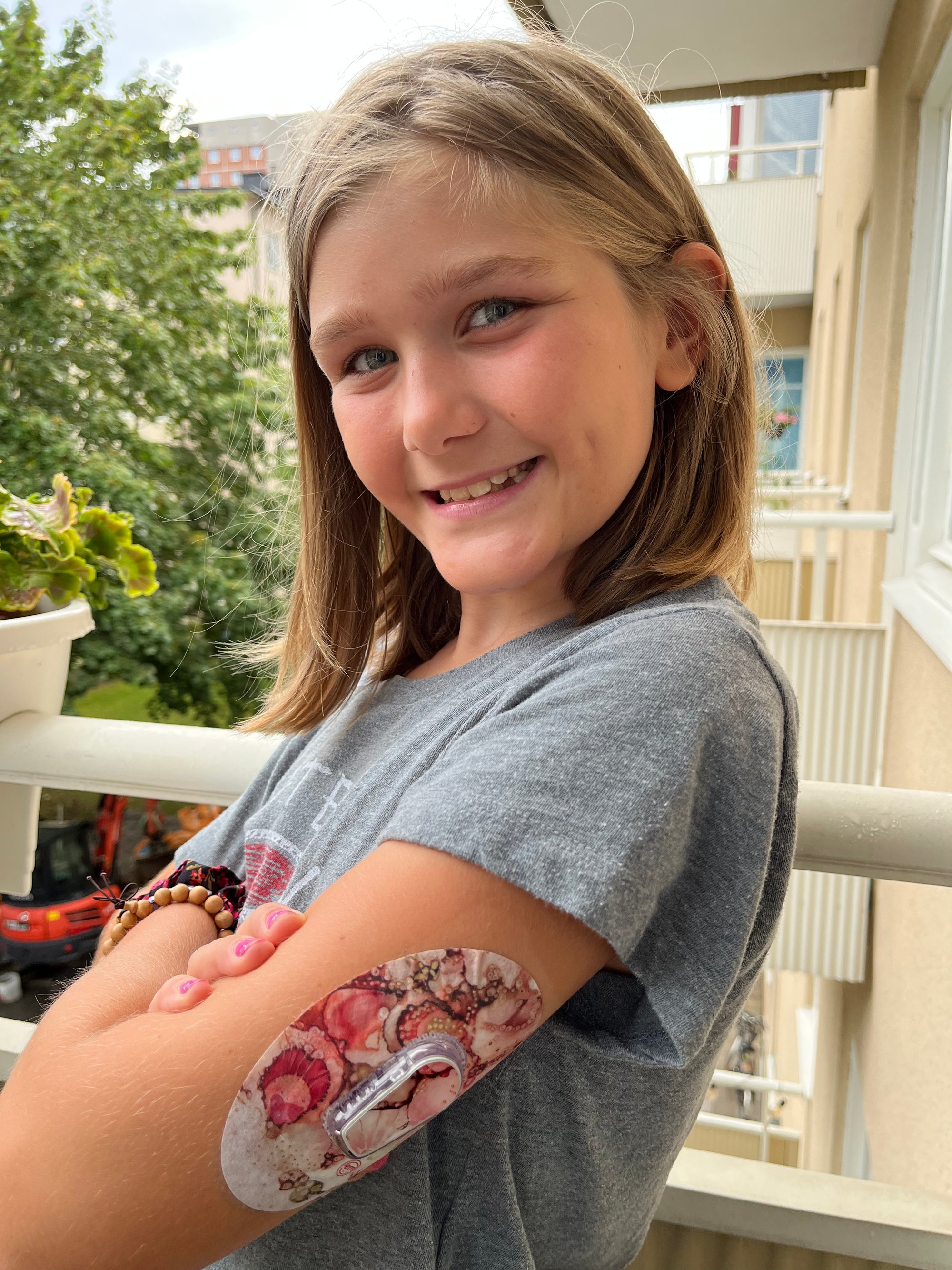 ExpressionMed Artful Shells Dexcom G6 Tape, Single, Young girl wearing pink ocean shells themed CGM fixing ring patch design