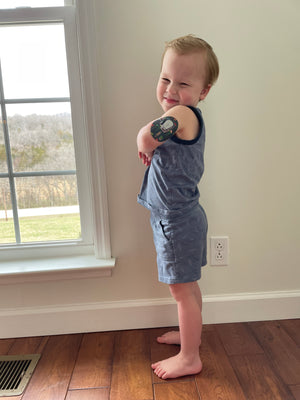 Smiling little boy with Just Jellies Dexcom G6 Tape on arm