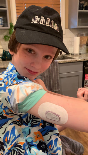 Boy wearing white UnderPatch with Dexcom G6 for sensitive skin